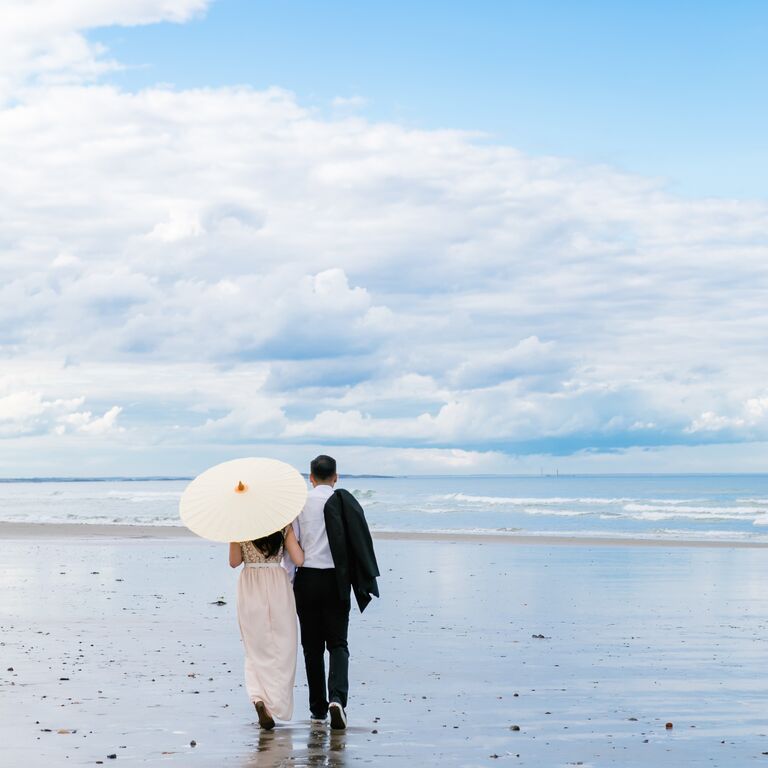 Beach engagement photoshoot with sunny parasol
