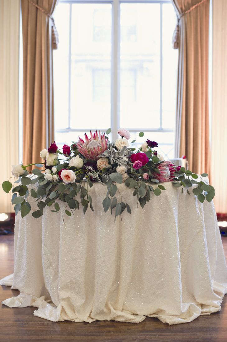 Large proteas, roses and eucalyptus decorated a table at the entrance to the reception.