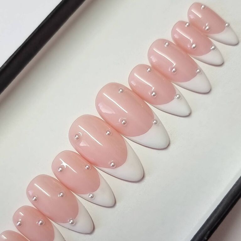 Bubblegum-pink set of press on nails with pearl embellishments. 