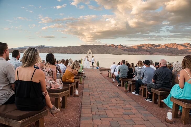 Christa and Jesse exchanged vows at dusk at the newly renovated Havasu Springs Resort in Parker, Arizona, on a cliff that overlooked Lake Havasu. To add even more ambiance, the aisle was lined with oversize candles filled with desert sand.