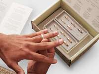 Image of a man trying on wedding bands at home. 
