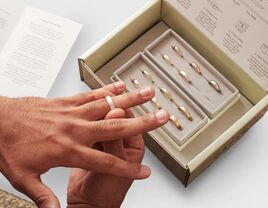 Image of a man trying on wedding bands at home. 