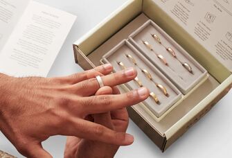 Image of a man trying on wedding bands at home. 