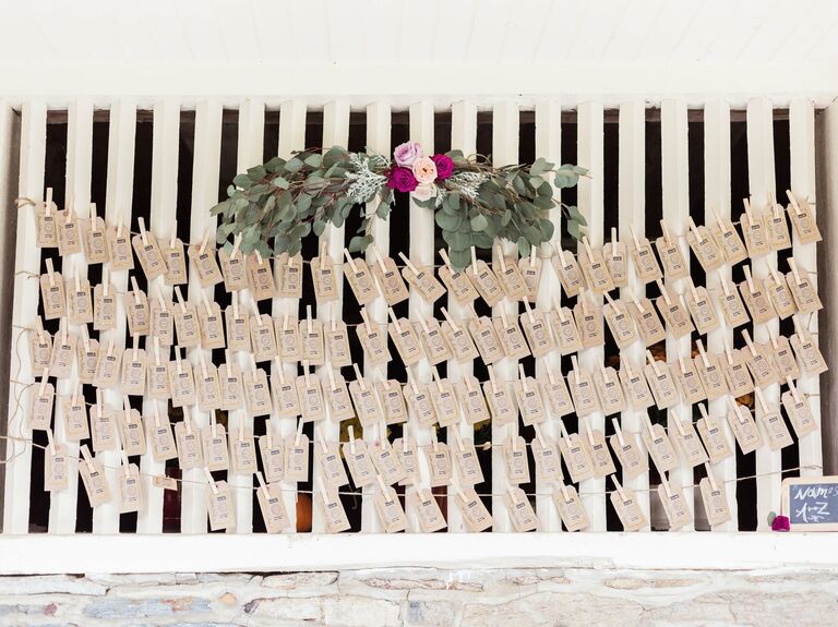 Rustic escort card display with a bohemian floral arrangement. 