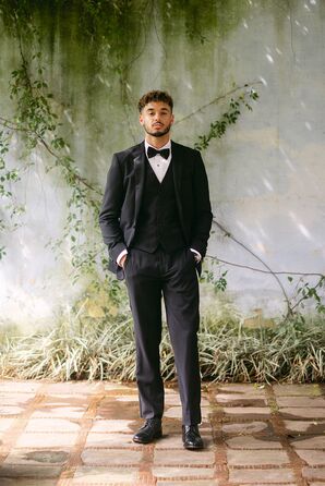 Groom in Classic Black Tuxedo With Black Vest, Bow Tie in Ancient Courtyard