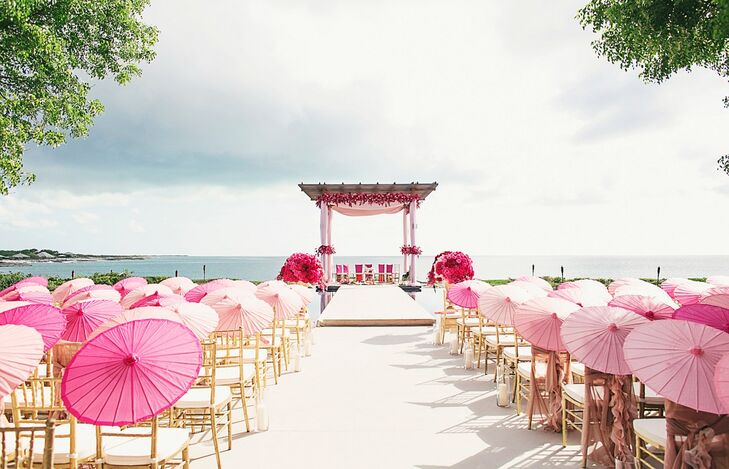 To keep the focus on the striking beauty of the  Amanyara resort in Turks and Caicos, Melanie and Neeraj kept the ceremony decor more simplistic. Using gold chiavari chairs and parasols in shades of pink, planner Sonal Shah created an ombre effect leading to the mandap. The mandap was draped in blush pink fabrics and highlighted with bright pink flowers. "It was important for us to keep the decor elegant and not compete with the natural beauty of the surroundings," Melanie says. "I got emotional when I witnessed the whole thing come together in person. It was a dream!"