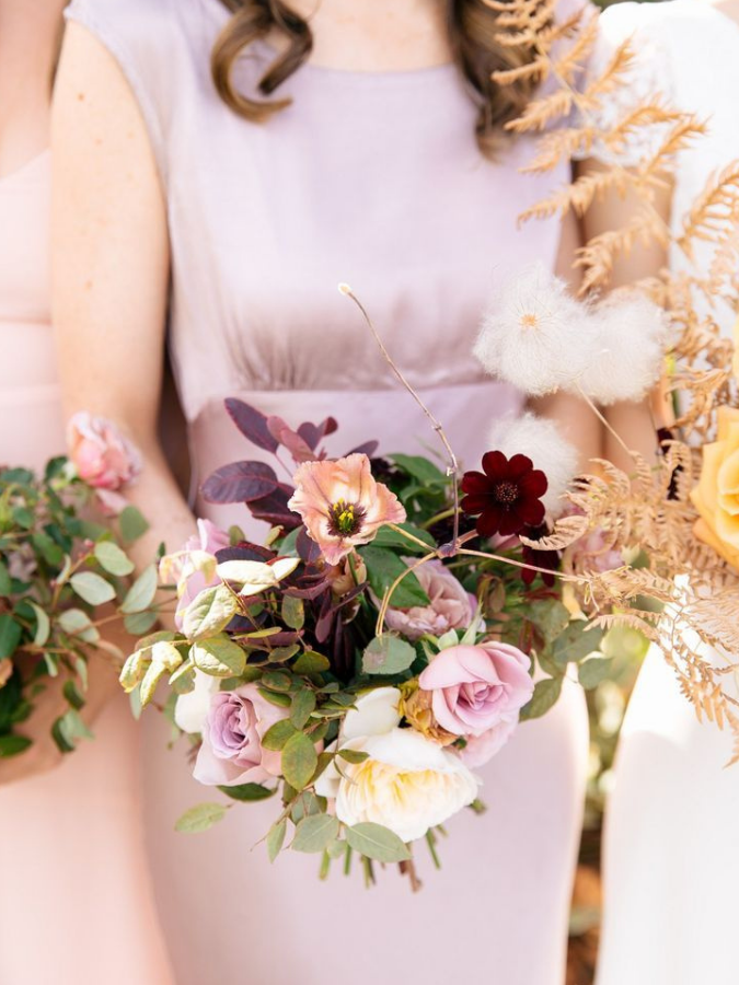 Bridesmaid in purple dress holding bouquet