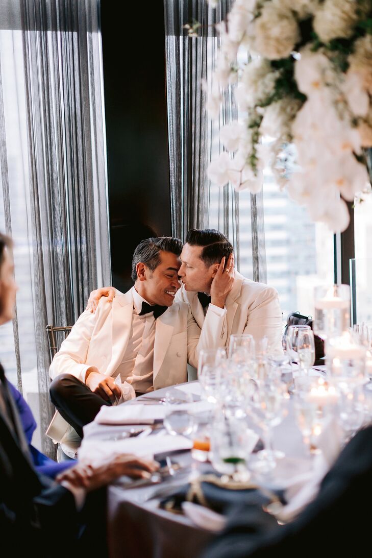 Elegant Grooms in White Tuxedos at Restaurant Reception