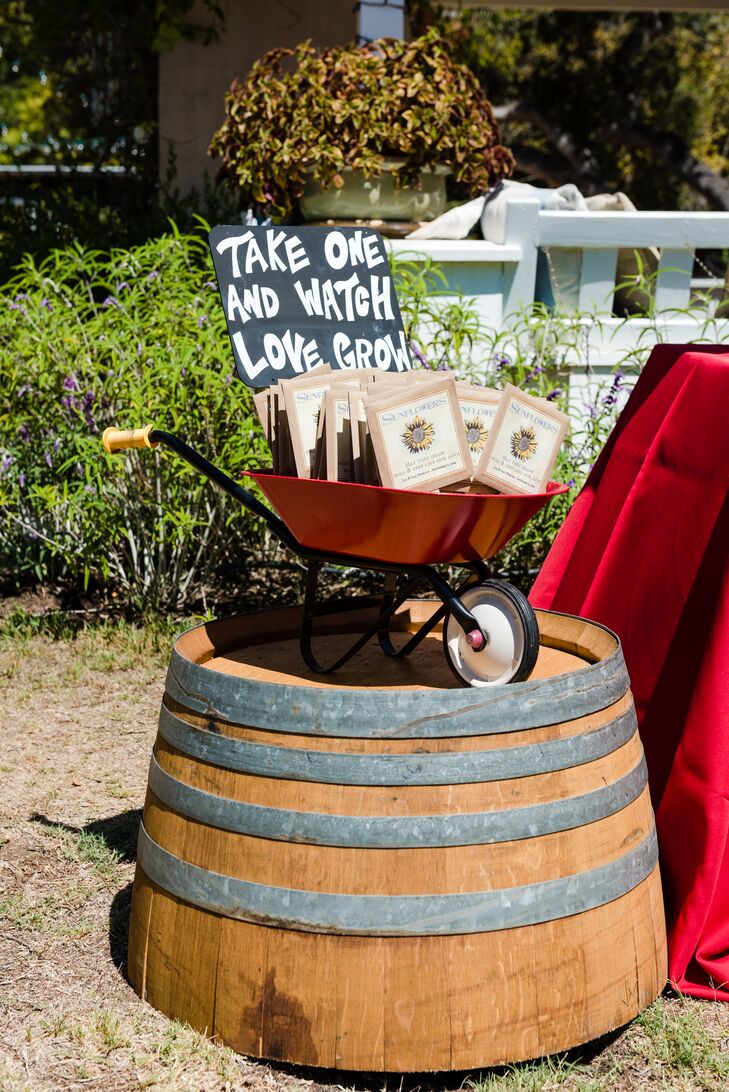 “Sunflowers are symbolic of adventure, laughter, and bonding with friends and relatives, so a perfectly filled customized packet of sunflower seeds was offered to our guests from inside a bright red wheelbarrow atop a half wine barrel. The message on each packet read: May they grow wild and deep like our love.”