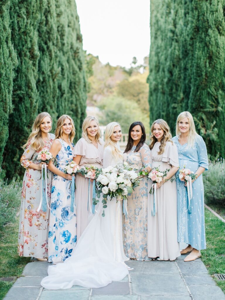 Bridesmaids wear mismatched floral gowns. 