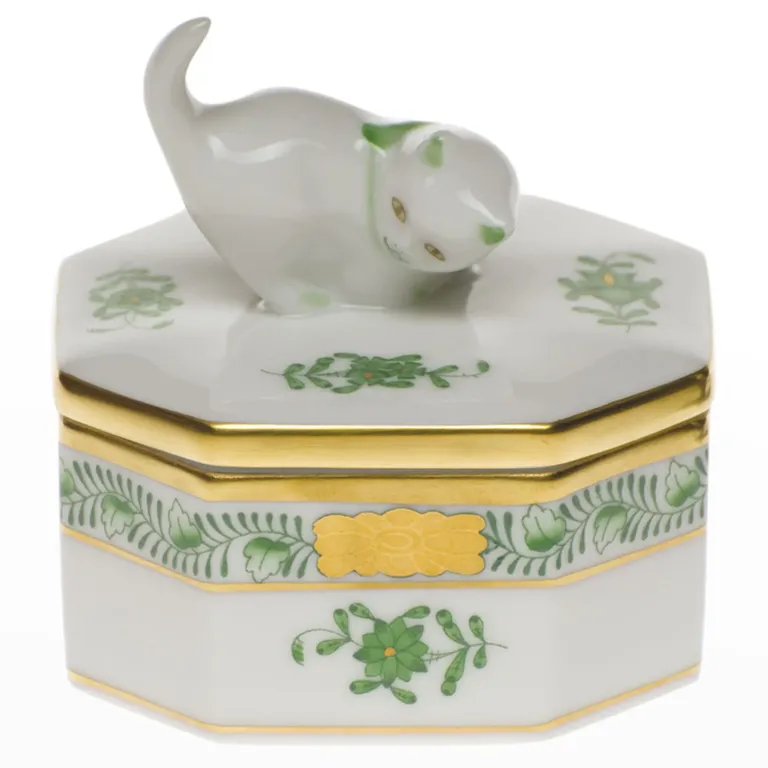 A porcelain jewelry box with a green and gold Chinese floral design and a cat on top from Neiman Marcus