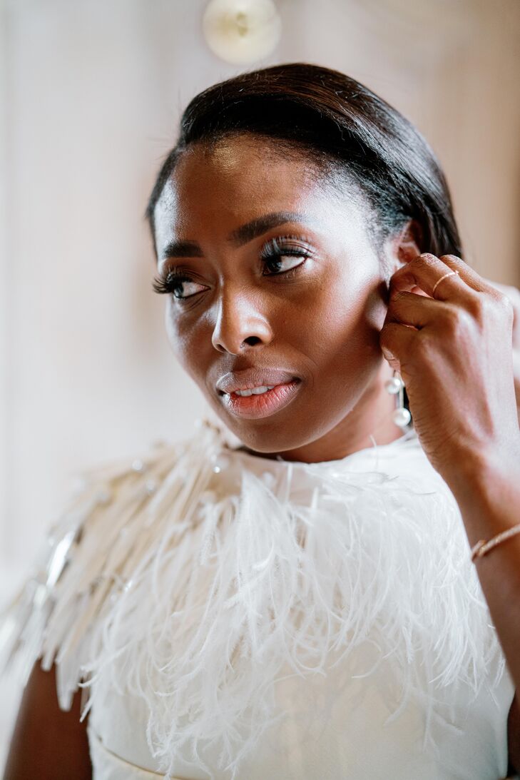 Bride in Beaded Wedding Dress Getting Reading and Putting on Earrings