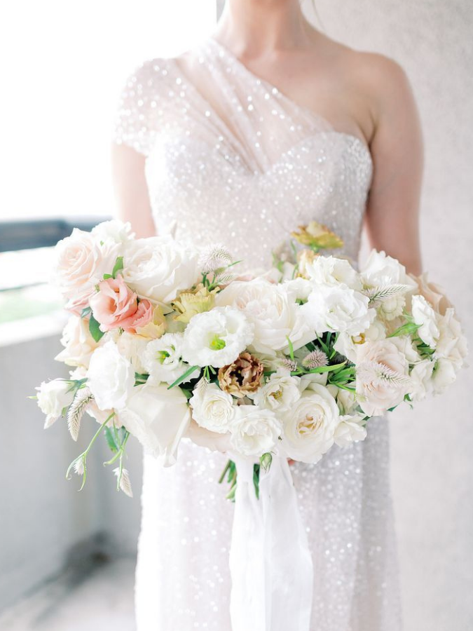 Bride in white dress with all-white bouquet
