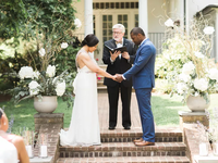 Couple with officiant during wedding ceremony.