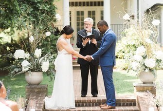 Couple with officiant during wedding ceremony.