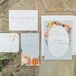The wedding's romantic garden theme was expressed through colorful floral illustrations on pale blue stationery and enhanced with shimmering gold accents.