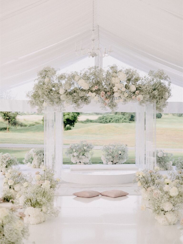 sikh wedding ceremony with floral arch of baby's breath and white flowers