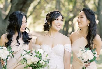 Bride and her bridesmaids smile for the camera. 