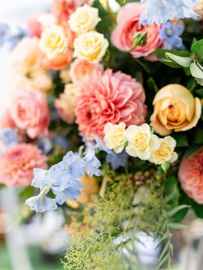 Pastel pink, yellow and blue flowers with sprigs of greenery