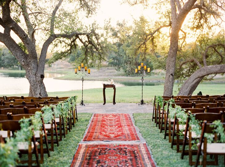 Cody wanted to be married by the water, so they had the ceremony in front of a spring-fed pond on the property. The bright red Turkish rug aisle runner led to the altar, where they got married underneath live oaks.
