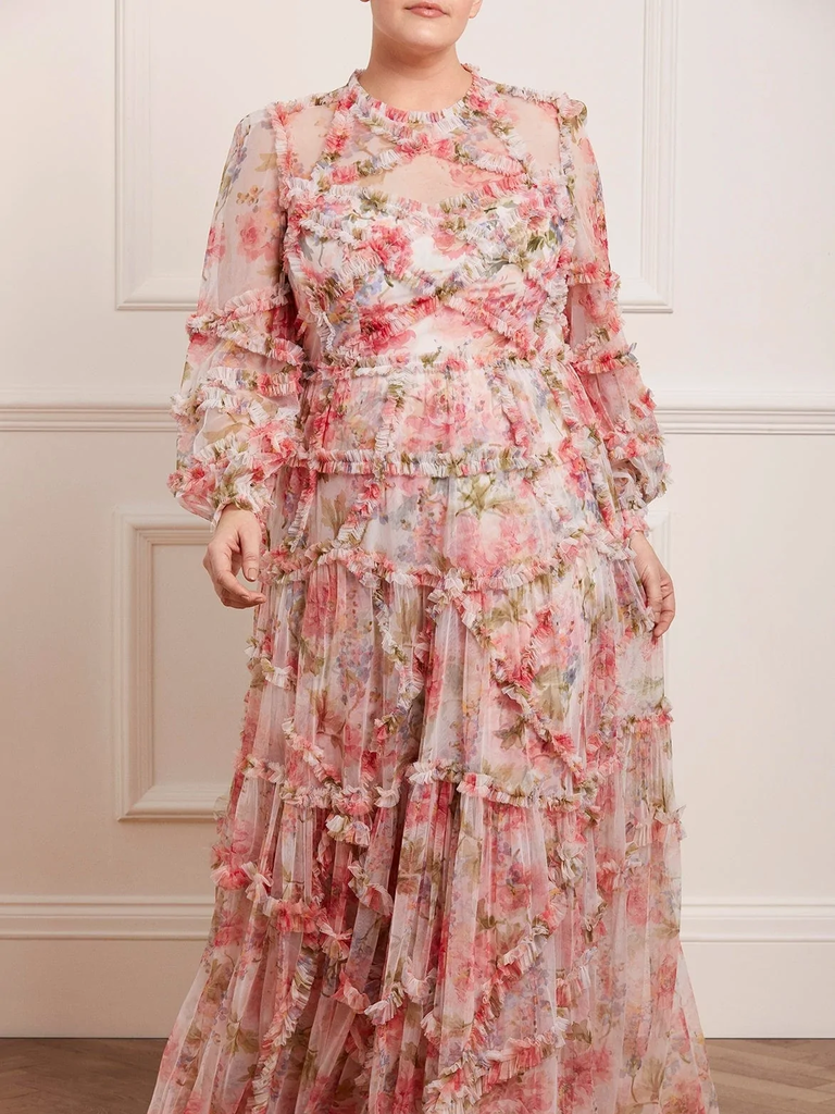 A model wears this lacy, floaty floral mother of the bride dress with long sleeves and a natural waist.
