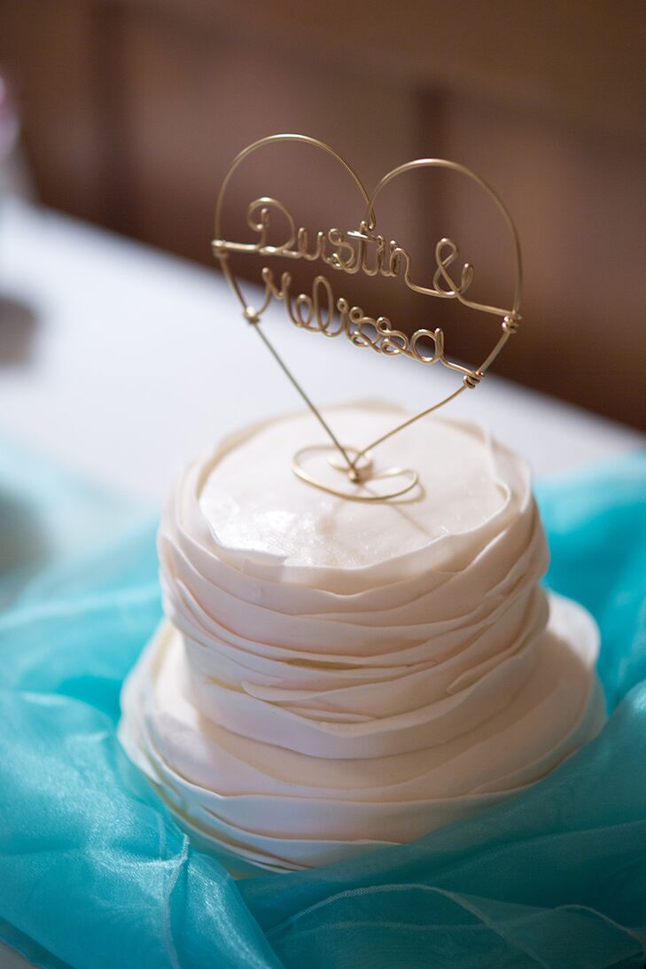 While Melissa and Dustin had a candy bar after a barbecue dinner, the couple decided to stick with tradition and had a small cake made for a cake cutting. The two-tier confection was covered in a layer of ruffled fondant and topped with a playful wire heart boasting their first names.