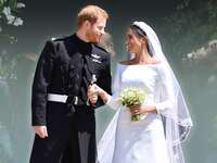 WINDSOR, UNITED KINGDOM - MAY 19: Britain's Prince Harry, Duke of Sussex and his wife Meghan, Duchess of Sussex leave from the West Door of St George's Chapel, Windsor Castle, in Windsor on May 19, 2018 in Windsor, England.