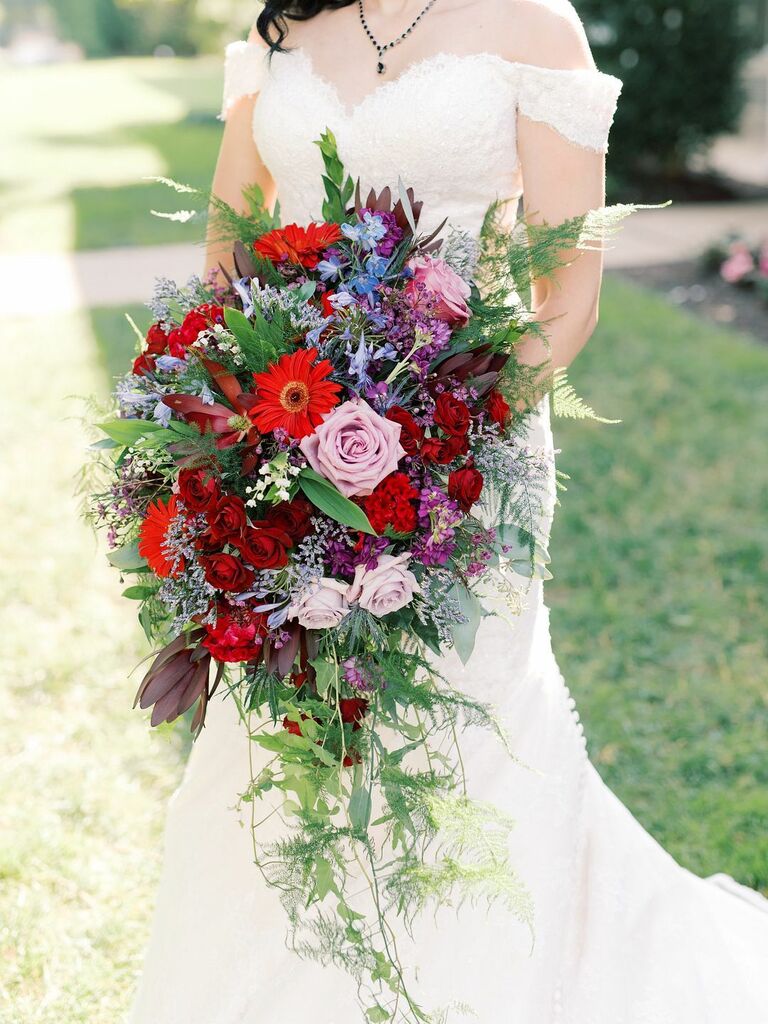 fall cascading wedding bouquet of burgundy, purple and blue flowers with greenery