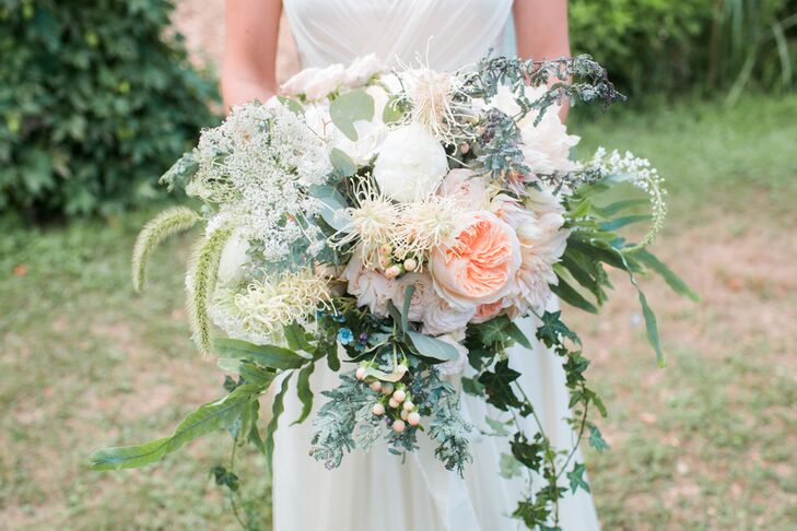 “I love dahlias, specifically cafe au lait dahlias, so I wanted them to be at the core of the floral design,” Megan says of her textured bridal bouquet. Seagrass Florals created a cascading arrangement filled with dahlias, garden roses, peonies, spray roses, vines and wildflowers in shades of ivory, blush, blue and green.