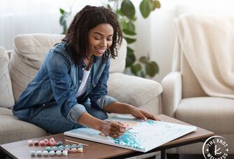 Woman on solo date painting by numbers at home