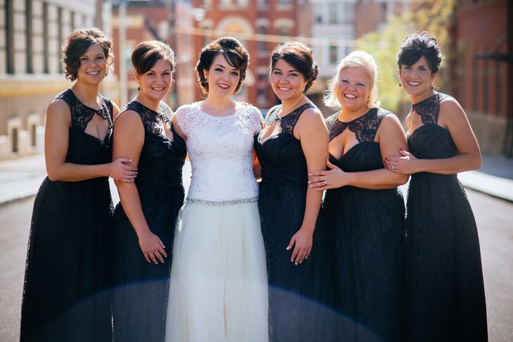 Anna stood in the middle of her bridesmaids, who wore charcoal gray Amsale dresses with a keyhole front accented with lace. Each wore her hair styled into an updo, with square emerald green earrings that matched Anna's own studs.