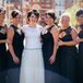 Anna stood in the middle of her bridesmaids, who wore charcoal gray Amsale dresses with a keyhole front accented with lace. Each wore her hair styled into an updo, with square emerald green earrings that matched Anna's own studs.