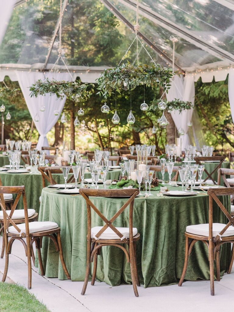 tented wedding reception with greenery chandelier and green tablecloths