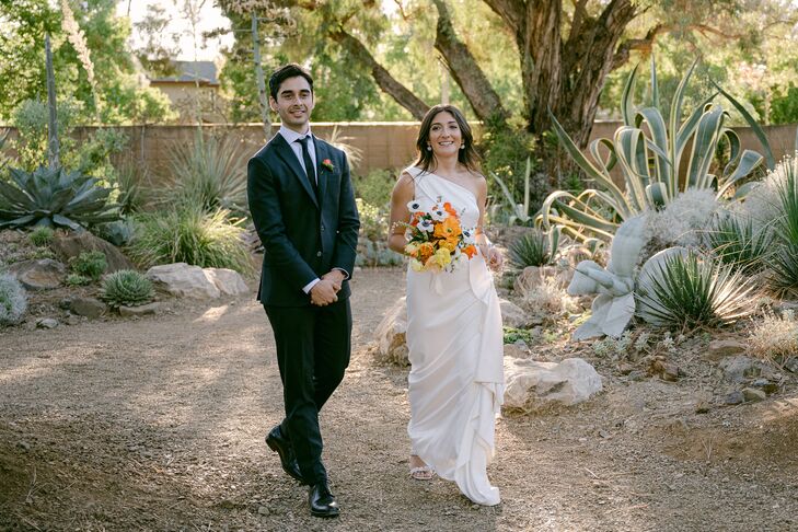Groom in Classic Black Suit, Bride in One-Shoulder Gown With Colorful Bouquet in Garden