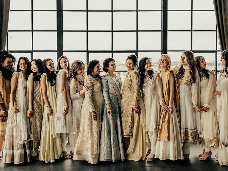 Bridesmaids wear beautiful dresses in various shades of white and cream. 
