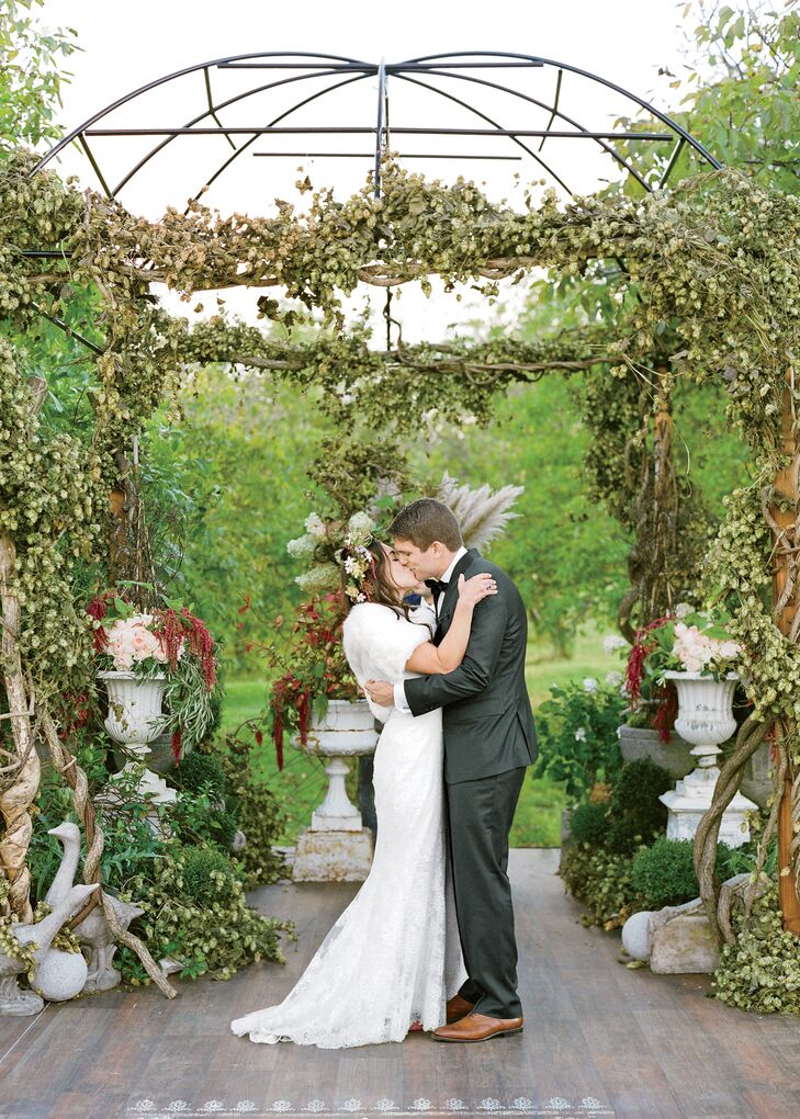 The couple married beneath a lush arbor dripped with vines and hops.