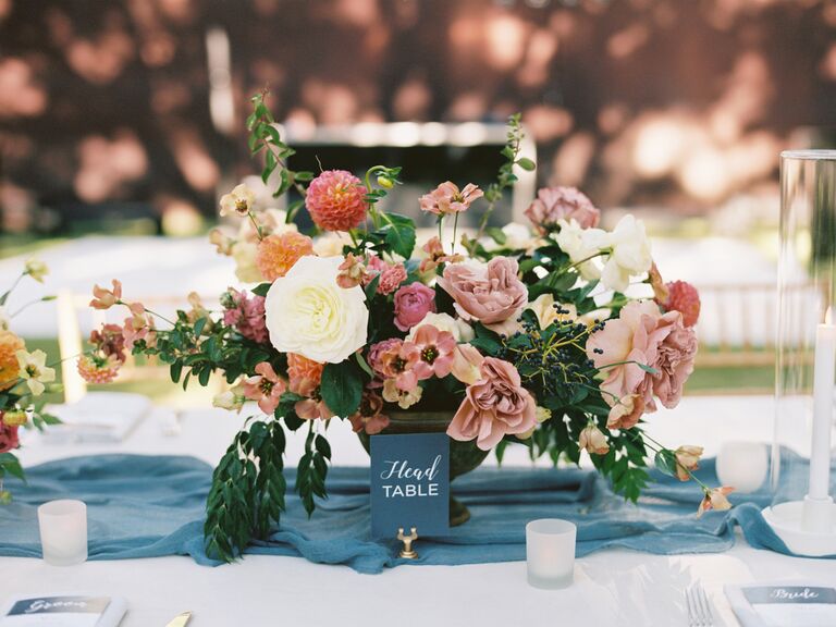 fall wedding centerpiece with mauve garden roses, pink dahlias, greenery and blue gauze table runner