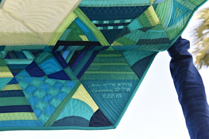 "The centerpiece of our decor was our chuppah: a one-of-a-kind quilt that I designed to include the full range of our color palette," Julie says. "The  call was put out to quilters around the world for 222 unique triangle quilt blocks, and the response was impressive. Our chuppah is a hexagon-shaped quilt with a Star of David in the center, and the star is surrounded by a ring of 54 blocks, each made by us, our families and close friends. The outer ring of 168 blocks is a collection of blocks contributed by quilters near and far who lovingly wished to support us on our wedding day."