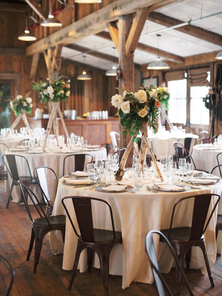 rustic wedding centerpiece idea with flowers on top of tall birch branches