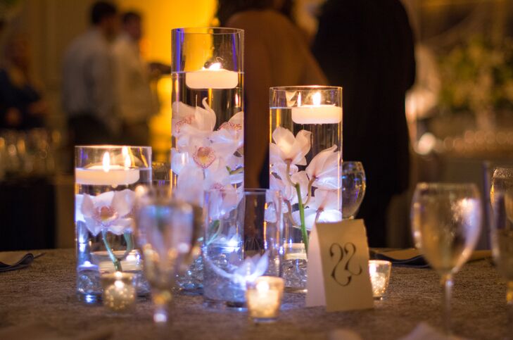 As a contrast to tall flower arrangements filled with hydrangeas, roses, stock, electric blue delphinium andrncalla lilies, certain tables were decorated with clear cylinders filled with submerged flowers.