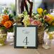 The reception tables were numbered with simple folded paper table numbers decorated with white and yellow ribbon and finished with the couple’s monogram in gray calligraphy-style typography.