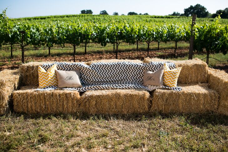 Black and white zigzag patterned linens and square pillows decorated stacks of hay bales, matching the country style and serving as lounge furniture for friends and family during the outdoor festivities.