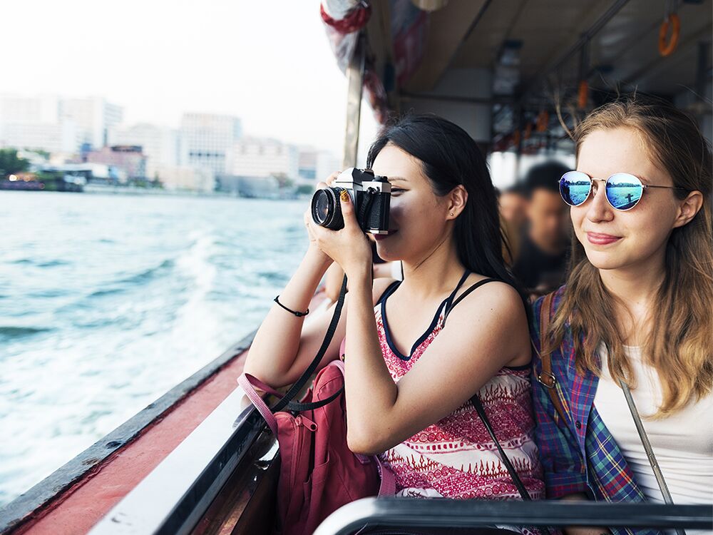 Couple riding on boat while one takes photos
