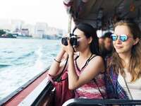 Couple riding on boat while one takes photos