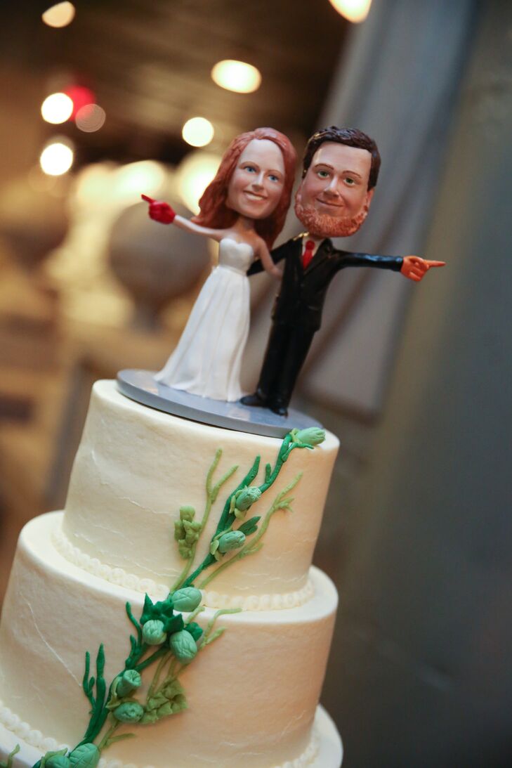 Buttercream hop vines crawled up the side of the wedding cake topped with a custom bobblehead of the couple.