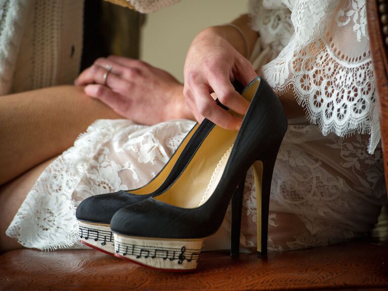 Bride holding music note high heels.