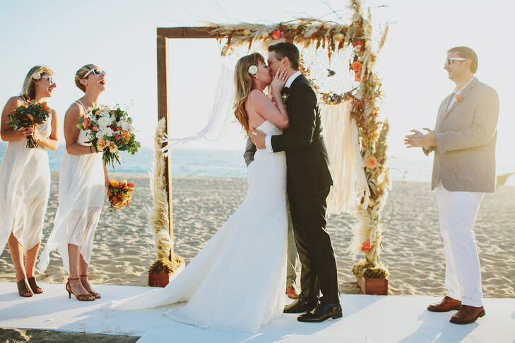 Gwynne and David said their vows under a simple wooden arch decorated with bright orange rose blossoms and a dream catcher.