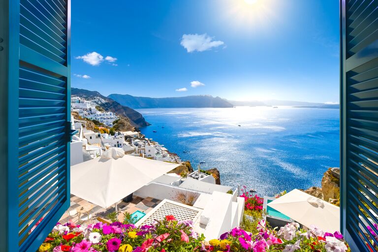 santorini window view stunning of white washed rooftops and florals and the Mediterranean