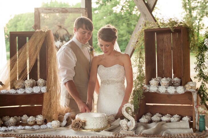 Lauren and Jordan had a single-tier cake covered in textured white buttercream, accented by a burlap flower. They also served white cupcakes to their 120 guests.