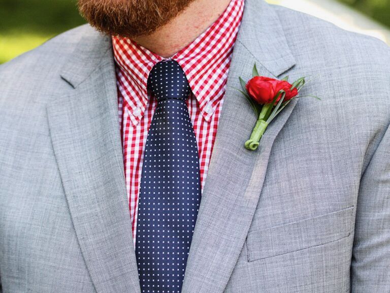 close-up of groom wearing gray wedding suit jacket with red gingham shirt and navy blue polka dot tie